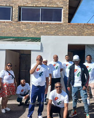 ETM leadership and members outside a community building